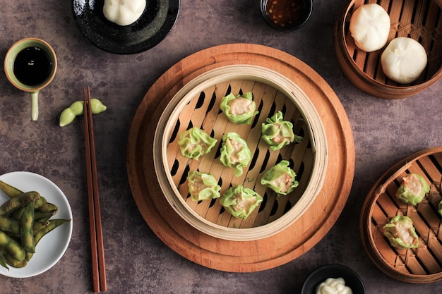 Divers plats chinois à plat, Dim Sum sur un cuiseur vapeur en bambou au-dessus d'un plateau en marbre