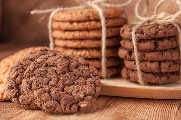 Divers sablés, biscuits à l'avoine, biscuit aux pépites de chocolat sur une table en bois rustique foncé.