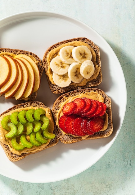 Divers sandwichs au beurre d'arachide et fraises, céleri, banane et pomme