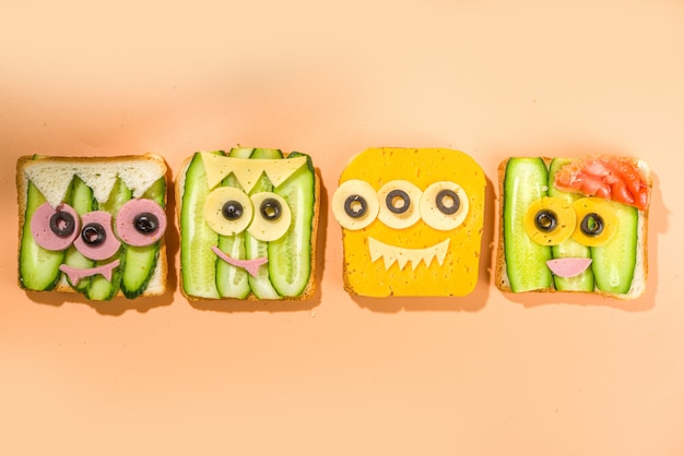 Divers sandwichs d'Halloween monstre drôle. Définir un assortiment de toasts de petit-déjeuner créatifs avec du fromage, de la nourriture de fête pour les enfants d'Halloween, vue de dessus