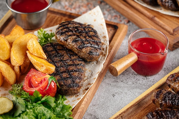 Divers steaks de boeuf grillés avec sauce et garniture