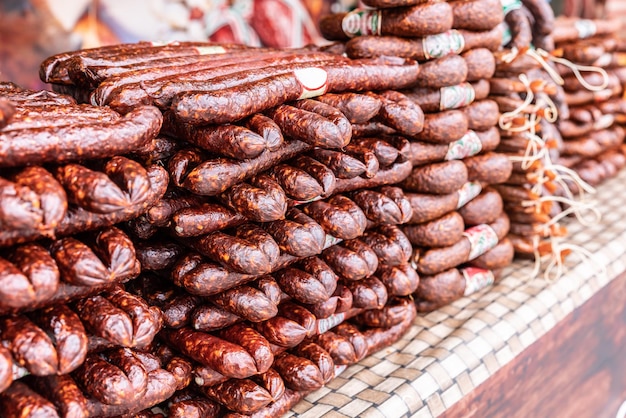 Divers types de saucisses fumées entassées à vendre sur le marché