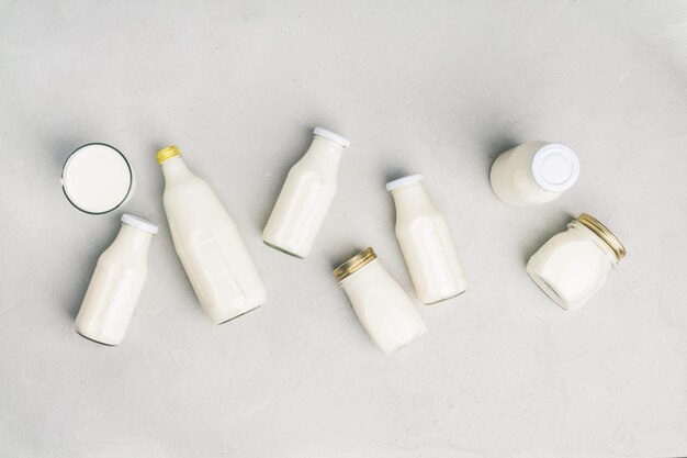 Diverses bouteilles de lait sur un fond de béton gris