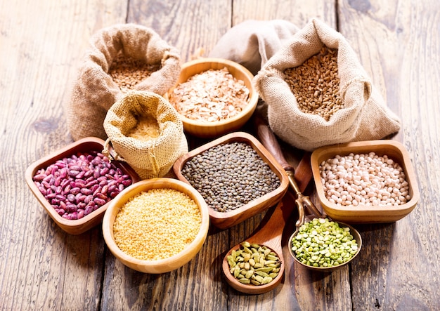 Diverses céréales, graines, haricots et grains sur table en bois