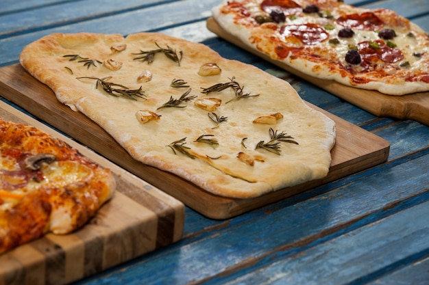Diverses délicieuses pizzas italiennes servies sur planche de bois