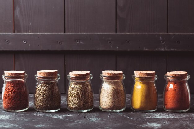 Diverses épices broyées dans des bouteilles en verre vintage