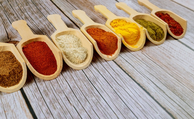 Diverses épices en cuillères en bois sur une table en bois