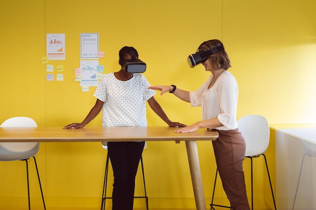 Diverses femmes d'affaires debout au bureau utilisant un casque vr au travail