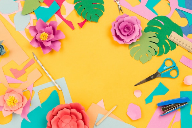 Diverses fournitures fixes, papier de couleur, fleurs en papier sur table jaune