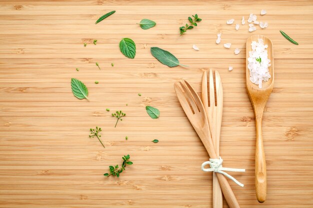 Diverses herbes aromatiques et épices mis en place sur fond de bois.