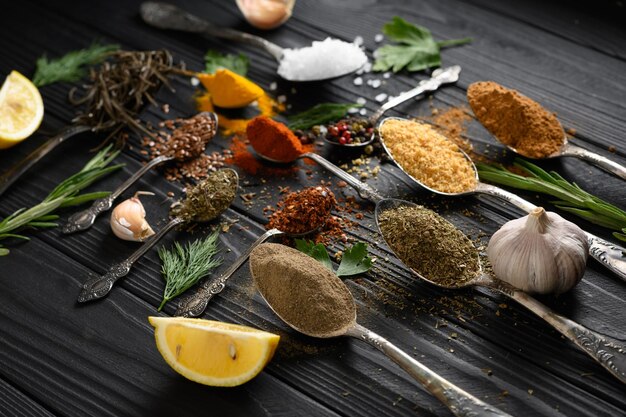 Photo diverses herbes et épices colorées pour la cuisson sur fond rustique en bois foncé