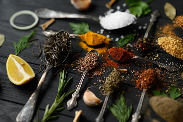 Photo diverses herbes et épices colorées pour la cuisson sur fond rustique en bois foncé