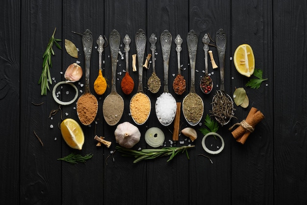 Diverses herbes et épices colorées pour la cuisson sur fond rustique en bois foncé