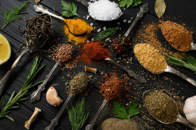 Diverses herbes et épices colorées pour la cuisson sur fond rustique en bois foncé