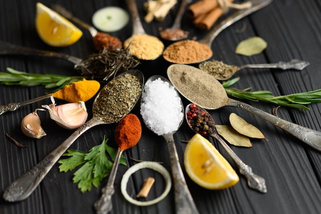 Diverses herbes et épices colorées pour la cuisson sur fond rustique en bois foncé