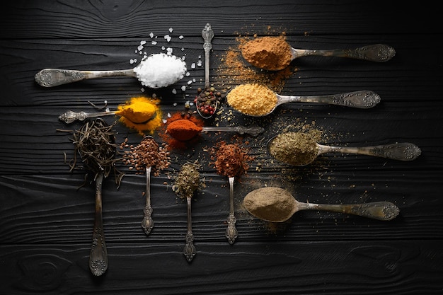 Diverses herbes et épices colorées pour la cuisson sur fond rustique en bois foncé