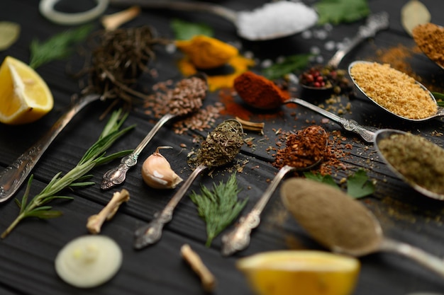 Diverses herbes et épices colorées pour la cuisson sur fond rustique en bois foncé