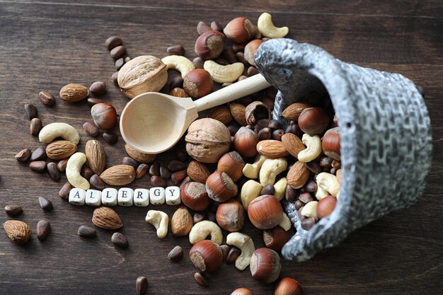 Diverses noix utiles et savoureuses sur une table en bois et des pots avec de l'herbe verte