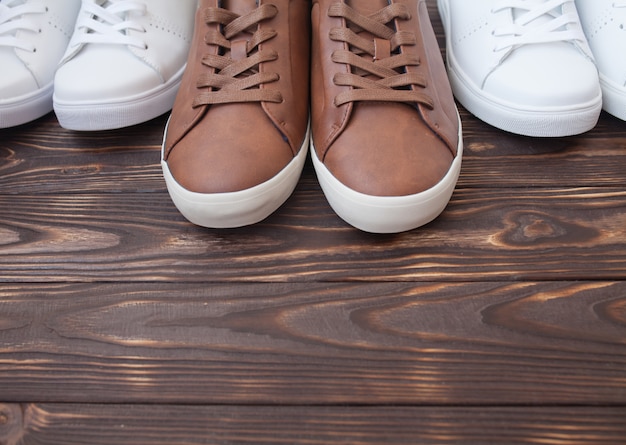 Diverses paires de baskets colorées posées sur le fond de plancher en bois