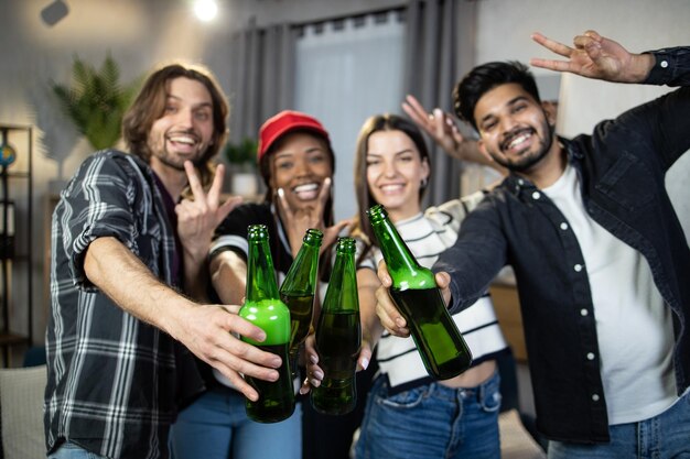 Photo diverses personnes avec de la bière souriant et faisant des gestes dans la chambre