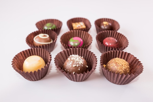 Diverses pralines au chocolat sur fond blanc. Bonbons dans un emballage.