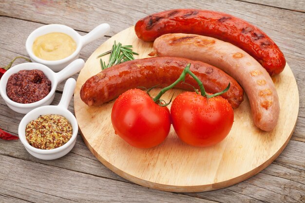 Diverses saucisses grillées avec condiments et tomates