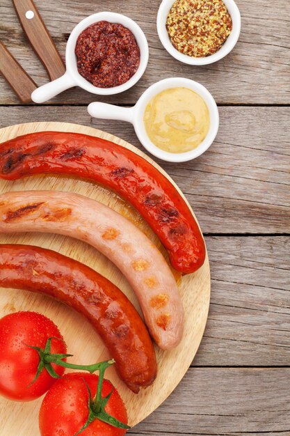 Diverses saucisses grillées avec condiments et tomates