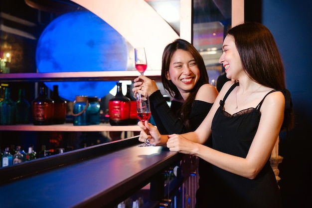 Diversité de femmes heureuses et souriantes riant tenant un verre de vin soirée d'anniversaire