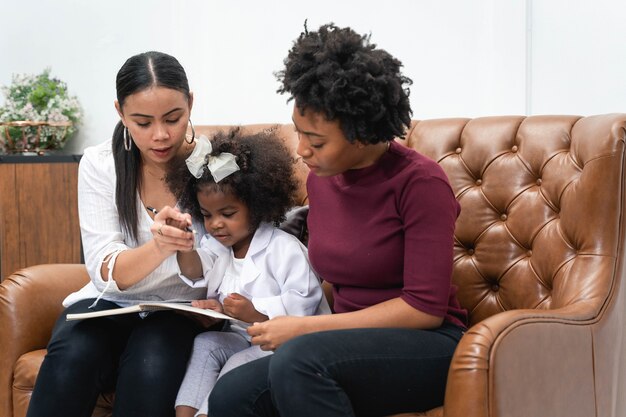 Diversité LGBT Couple de lesbiennes Moments de bonheur avec sa fille africaine en riant et en dessinant une photo