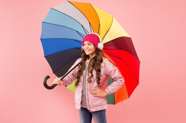 Divertissez-vous Concept amusant Se sentir bien Fille s'amusant à marcher avec des écouteurs sans fil sous un parapluie coloré Loisirs d'automne Musique toujours avec moi Amusement quotidien Enfant appréciant des choses simples