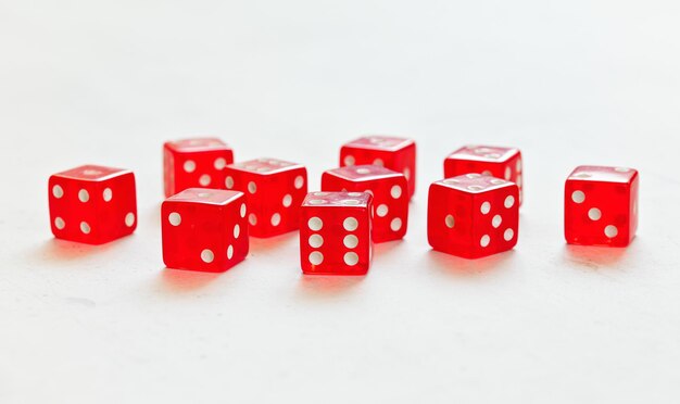 Dix dés de craps translucides rouges sur tableau blanc montrant différents nombres