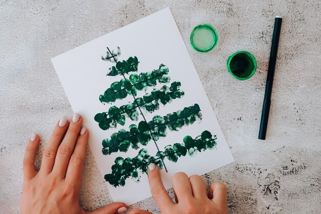 Photo diy faire des cartes de vœux artisanat fait à la main en vacances pour les enfants peindre avec les doigts joyeux noël