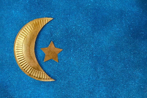 Diy Ramadan Kareem croissant de lune avec une étoile d&#39;une plaque de carton jetable et peinture dorée.