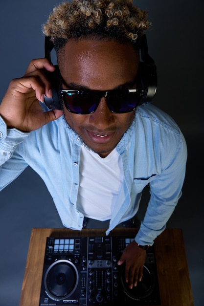 Un DJ afro-américain joue de la musique sur les platines et s'accroche aux écouteurs