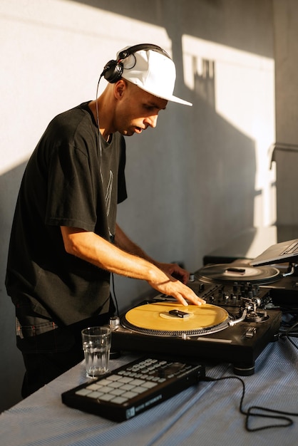 Dj dans les écouteurs joue lors d'un événement sur des disques vinyles et un mixeur