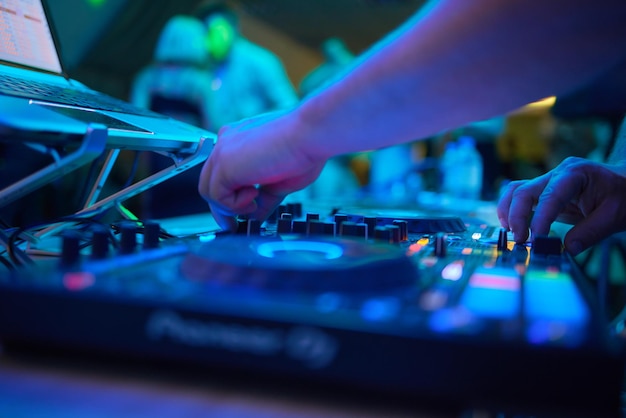 Photo dj est le mélange de musique avec le contrôleur de dj à la piscine d'été en plein air ou à la plage fête vie nocturne concept de style de vie des gens