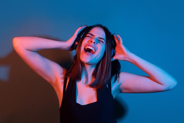 Dj fille excitée jeune femme écouter de la musique avec un casque dansant fille écoutant de la musique à l'aide de wirel