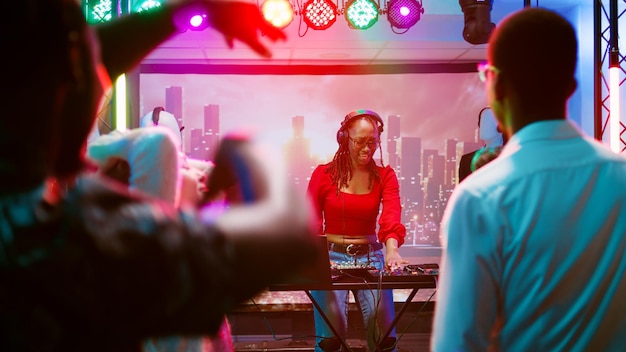 Photo une dj qui mélange de la musique dans une boîte de nuit.