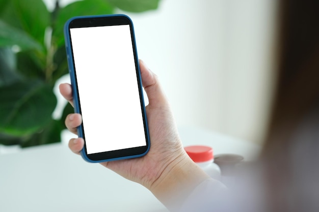 Docter woman hand holding smart phone avec blanc à l'écran