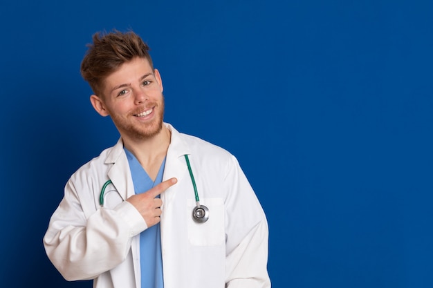 Docteur attrayant avec blouse blanche sur un bleu