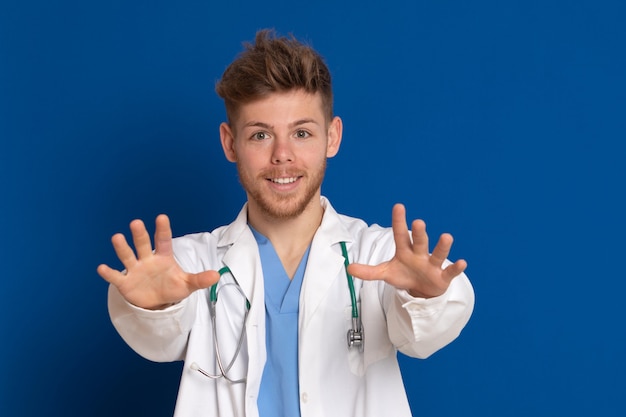 Docteur attrayant avec blouse blanche sur fond bleu