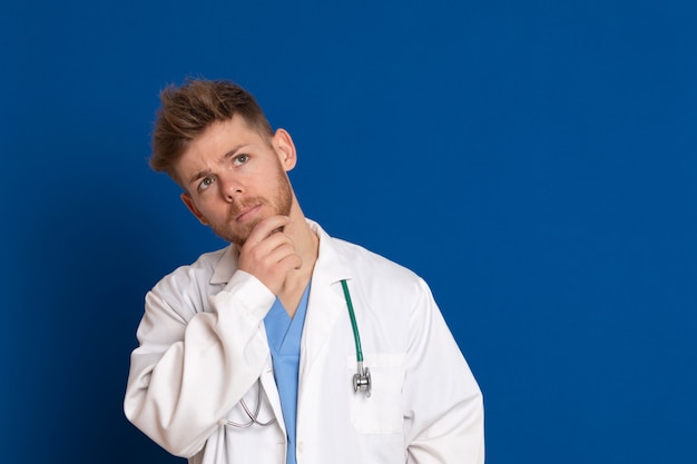 Docteur attrayant avec blouse blanche sur fond bleu