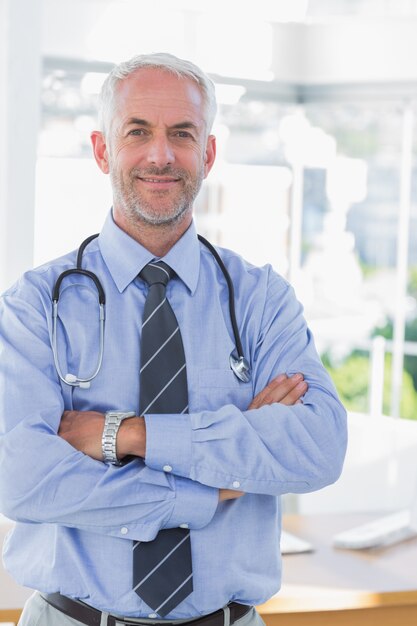 Docteur attrayant avec les bras croisés