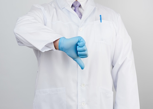 Photo docteur en blouse blanche à boutons montre un geste d'aversion avec sa main