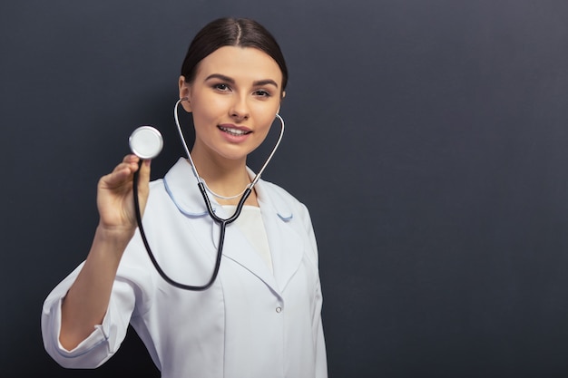 Docteur en blouse blanche tient un stéthoscope. Fond