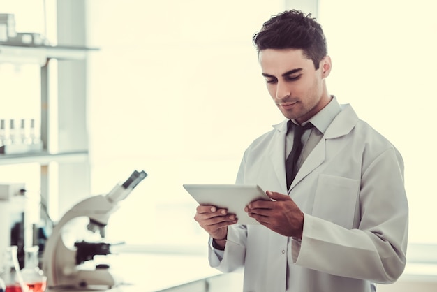 Docteur en blouse blanche utilise une tablette numérique.