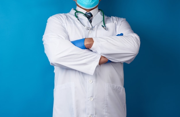 Docteur en blouse médicale blanche et gants en latex bleu se dresse sur un fond bleu