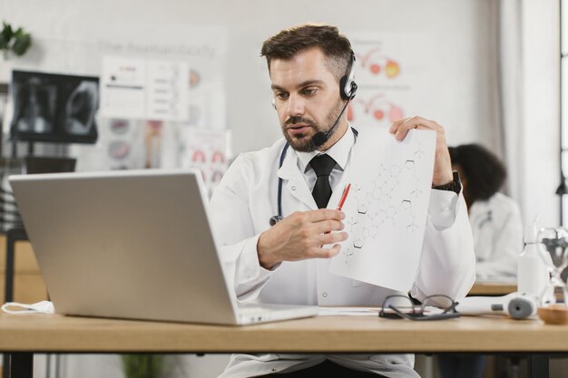 Docteur en casque ayant une discussion scientifique en ligne