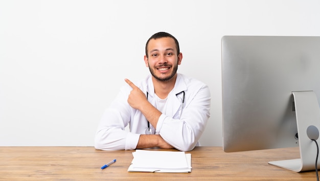 Docteur colombien pointant sur le côté pour présenter un produit