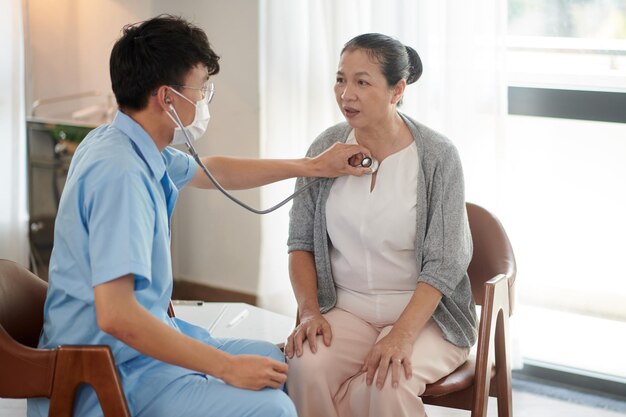 Docteur écoutant les poumons du patient